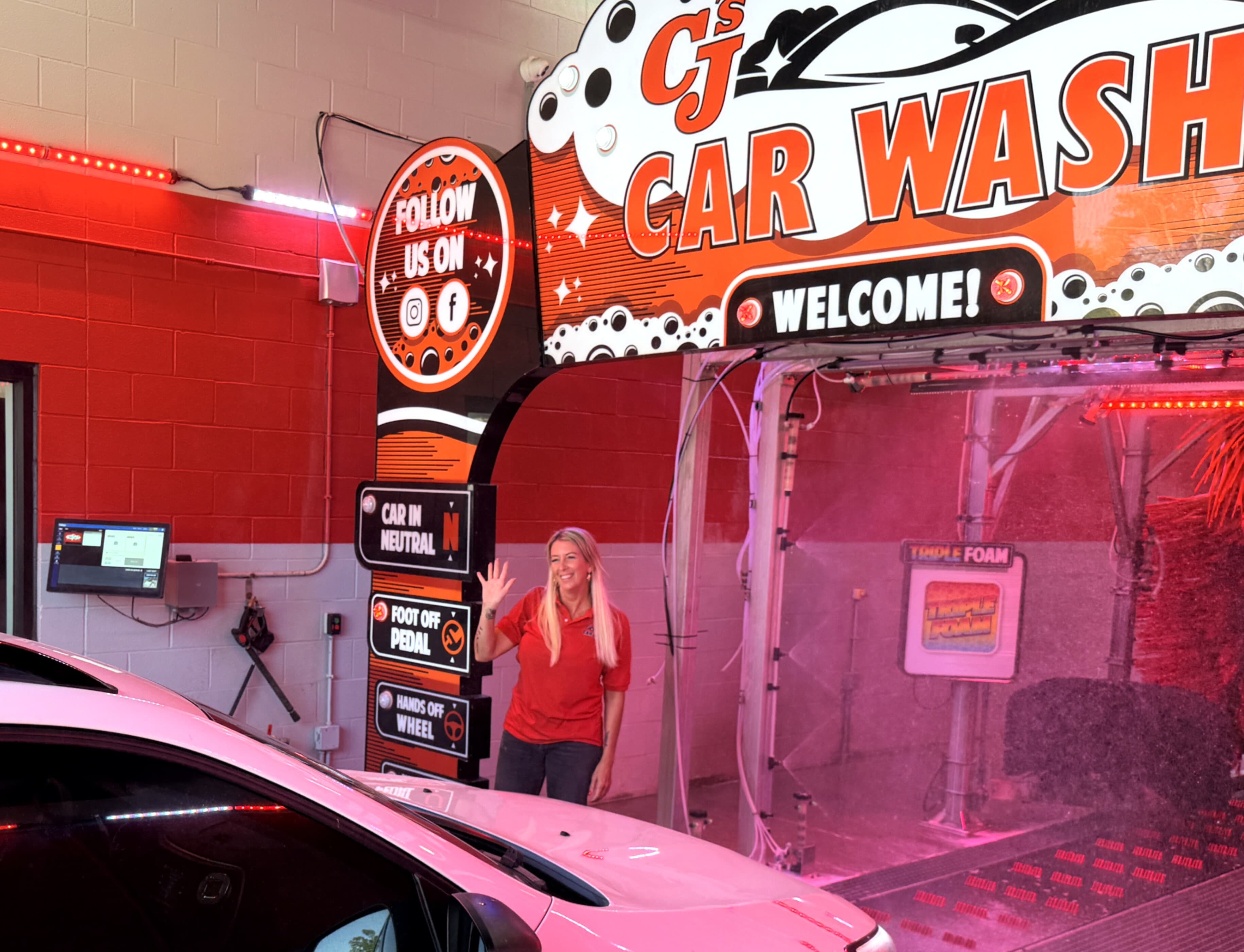 CJ's Car Wash attendant waving in the wash bay